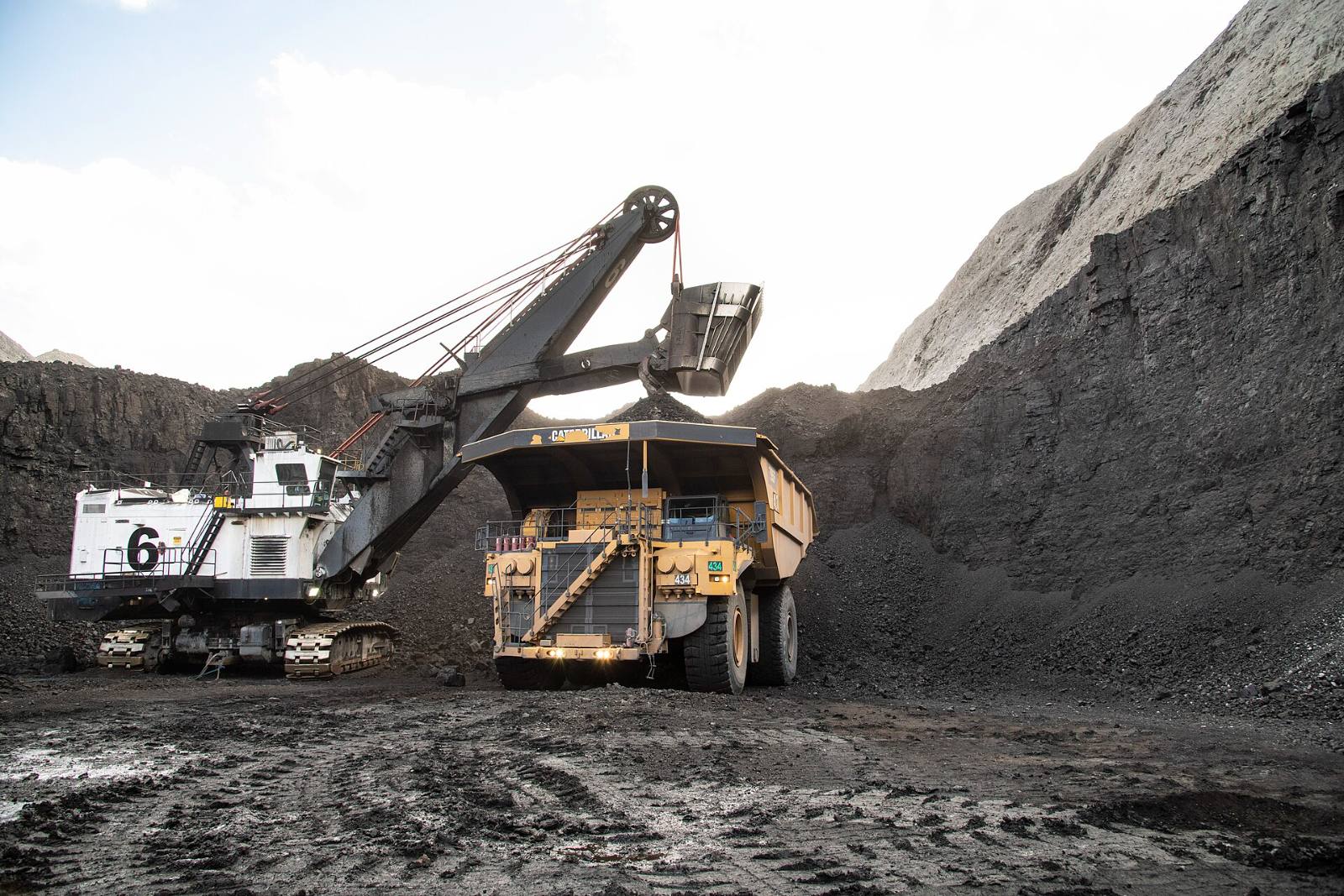 An electric rope shovel loading a haul truck with coal in an open-cast pit
