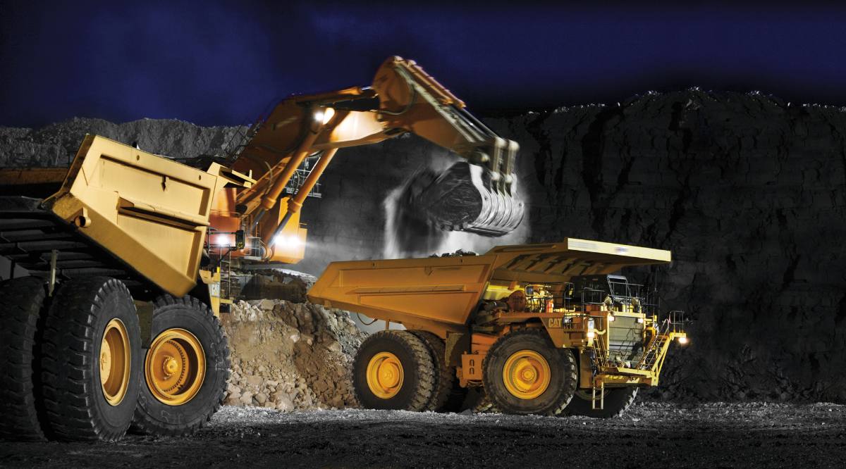 An excavator loading a haul truck at night